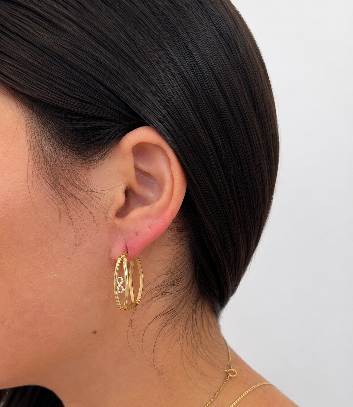 Argollas cuadradas con diseño de infinito en oro 14 kt