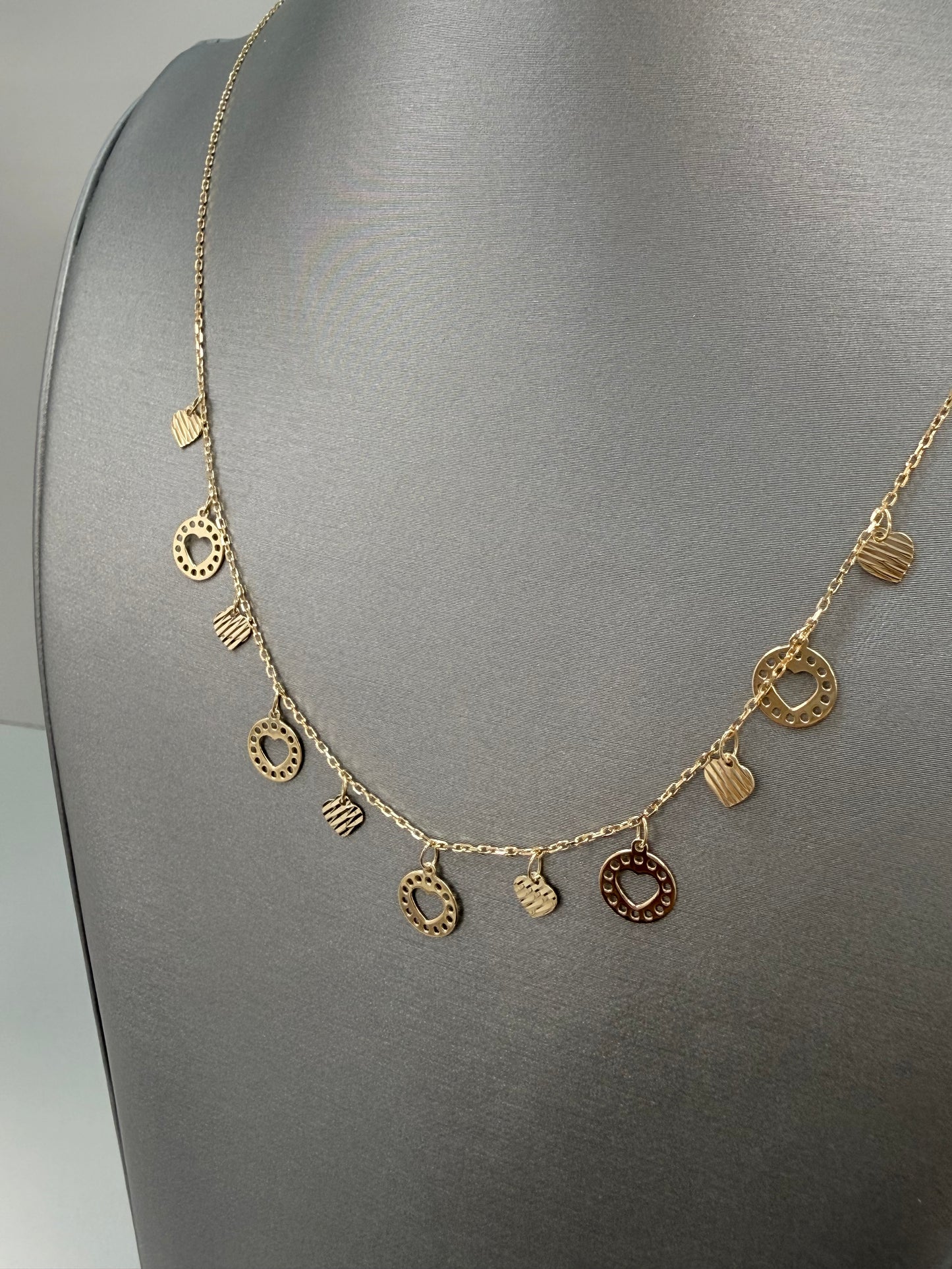 Cadena solida con diseño de corazones colgando en oro de 14 kt