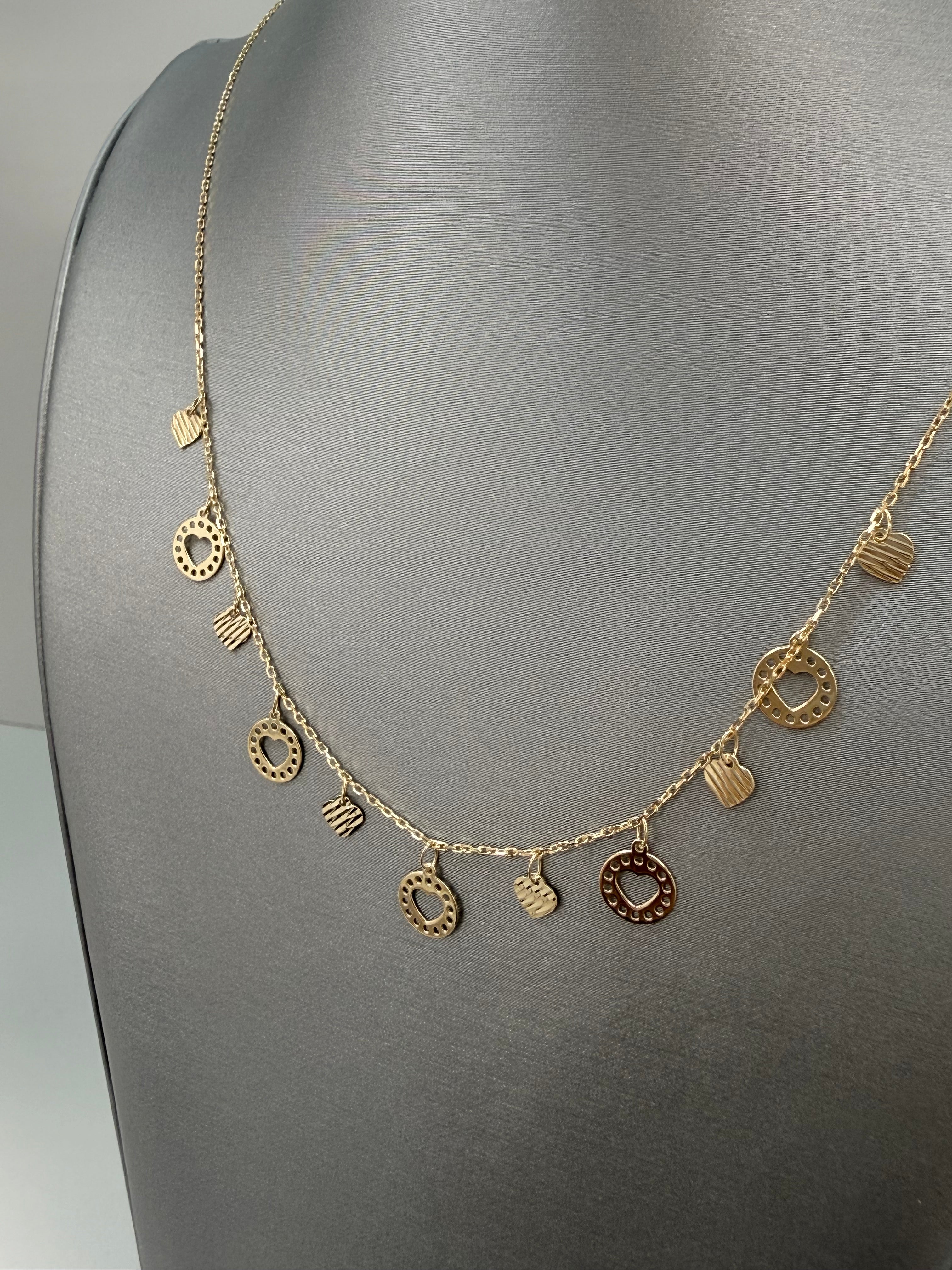 Cadena solida con diseño de corazones colgando en oro de 14 kt
